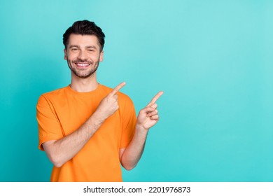 Portrait photo of young handsome positive confident nice man wear orange t-shirt fingers pointing empty space professional worker isolated on cyan color background - Powered by Shutterstock