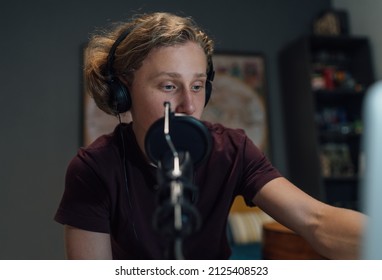 Portrait photo of a young teenager boy in headphones recording voice using microphone with pop filter. Modern home sound studio audio recording technology and teens hobby concept. - Powered by Shutterstock