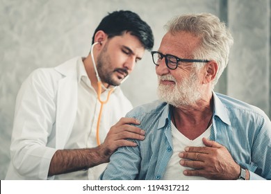 Portrait Of Physician Doctor Is Examining Physical Symptom Of Senior Patient In Examination Room, Practitioner Doctor Using Stethoscope To Health Checkup For Elder Old Man, Healthcare And Occupation 