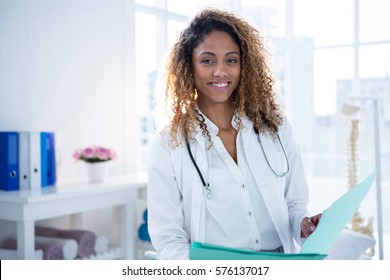 Portrait of physiotherapist holding clipboard in clinic