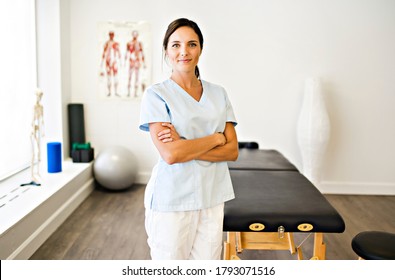 Ein Porträt einer Physiotherapeutin, die in Uniform lächelt