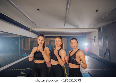 Portrait Picture Of Three Strong Women In Sportswear Posing In A Gym