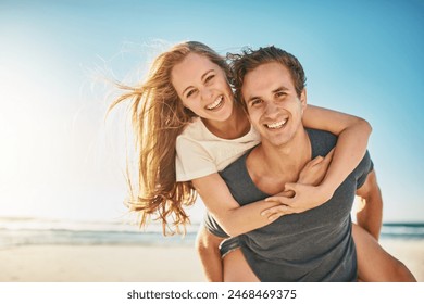 Portrait, piggy back and seaside with couple, love and sunshine with happiness, adventure and romance. Face, beach and man carrying woman with vacation, getaway trip or summer with honeymoon or smile - Powered by Shutterstock