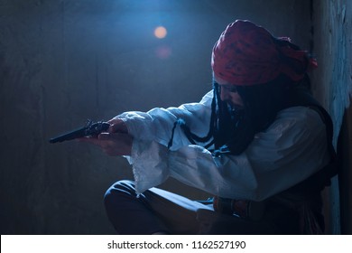 Portrait The Pirate With Black Dreadlocks, A Red Bandana And In A White Shirt With A Long Sleeve, Has Extended A Hand With A Gun And Aims. Blue Moonlight. Cinema Atmosphere