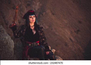 Portrait of a pirate woman at the beach. In anticipation of a pirate ship, sunset