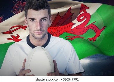 Portrait of a player holding rugby ball against fireworks exploding over football stadium - Powered by Shutterstock