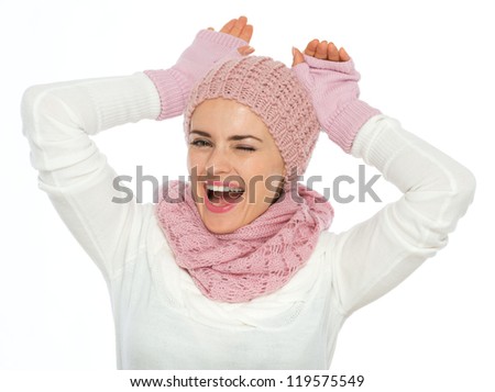 Portrait of playful young woman in knit scarf, hat and mittens