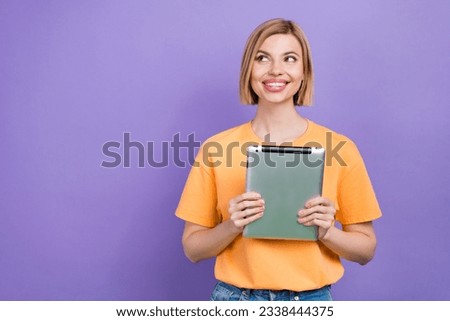 Portrait of pleasant intelligent woman with bob hairdo wear stylish t-shirt holding tablet look empty space isolated on purple background