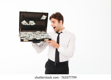 Portrait of a pleased young businessman dressed in white shirt holding briefcase full of money banknotes isolated over white background - Powered by Shutterstock - Get 15% off with code: PIKWIZARD15