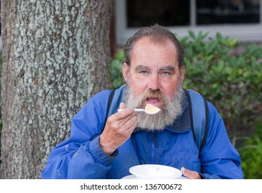 Portrait Of Poor Homeless Man Eating Food