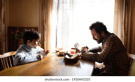 Portrait Of Poor Small Girl With Father Eating Indoors At Home, Poverty Concept.