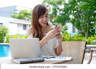 Portrait portraits of beautiful and pretty Asian women playing on mobile phones to use mobile applications. And surf the internet On her vacations by the pool - Shutterstock ID 1797475042