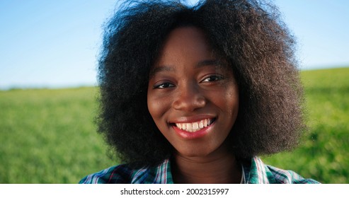 Portrait Of Positive African American Female Farmer With Vegetables Staying In Planting Or At The Field And Smiling To The Camera. Gardener, Agronomy And Agriculture Concept