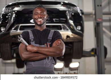 Portrait von positiven afro-amerikanischen Automechaniker in Uniform posiert nach der Arbeit, ist er auf die Reparatur von Autos, Autos.