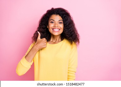 Portrait of positive cheerful african girl show thumb up recommend adverts choose choice decide decision wear good look isolated over pink color background