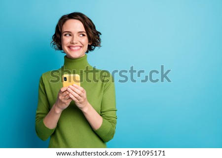 Portrait of positive cheerful girl use smart phone look copyspace share social media news wear style stylish trendy jumper isolated over blue color background