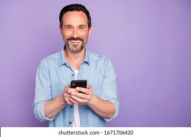 Portrait Of Positive Cheerful Man Use Cell Phone Have Rest Relax Text Type Sms Chatting With Friends Wife Wear Stylish Clothing Isolated Over Purple Color Background