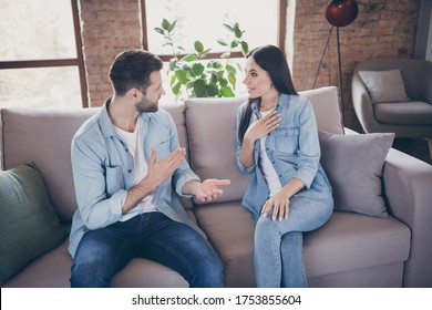 Portrait of positive cheerful spouses man woman have talk say tell incredible information secret rumor impressed touch hands chest sit couch in house indoors - Powered by Shutterstock