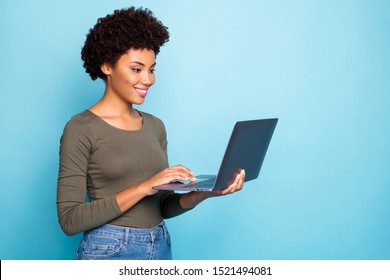 Portrait Of Positive Cool Confident Afro American Girl Freelancer Use Laptop Type Emails Chat With Her Partners Business Clients Wear Green Style Clothes Denim Jeans Isolated Blue Color Background