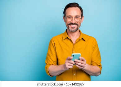 Portrait Of Positive Cool Man Use Cellphone Read Social Media News Information Blogging Post Comment Wear Good Looking Shirt Isolated Over Blue Color Background