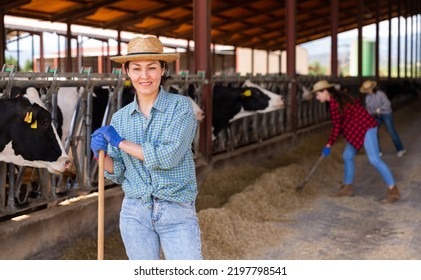 Portrait Of Positive Female Farm Worker In A Cowshed