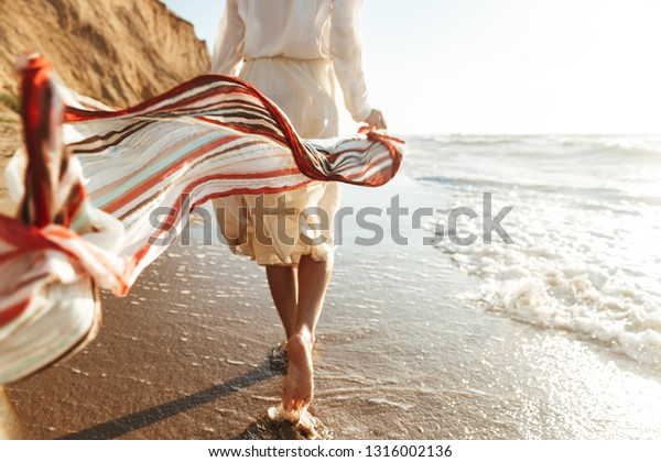海岸になびくスカーフを持つポジティブな女の子代のポートレート の写真素材 今すぐ編集
