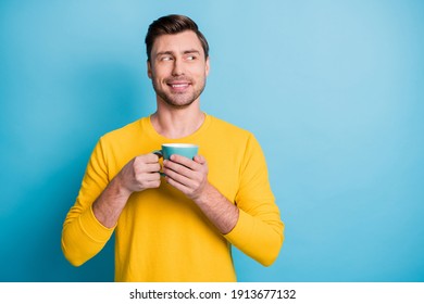 Portrait of positive handsome guy hands hold drink cup look interested empty space isolated on blue color background - Powered by Shutterstock