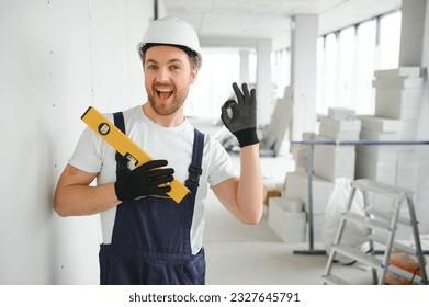 Portrait of positive, handsome young male builder in hard hat - Powered by Shutterstock