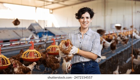 Portrait of positive highly experienced latin adult woman working in chicken farm - Powered by Shutterstock