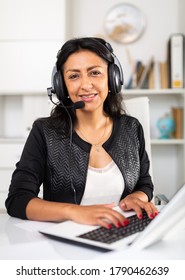 Portrait of positive latin american woman customer support phone operator at workplace