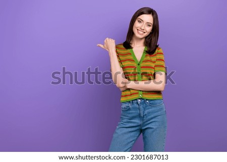 Portrait of positive lovely girl stylish hairdo dressed striped cardigan indicating empty space offer isolated on violet background