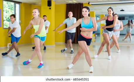 Portrait Of Positive Men And Women Dancing Zumba In Dance Class