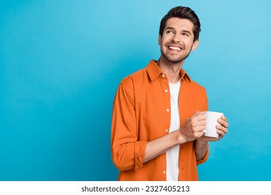 Portrait of positive minded creative person hands hold coffee mug look empty space brainstorming isolated on blue color background - Powered by Shutterstock