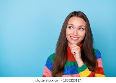 Portrait of positive minded girl look copyspace touch fingers chin think thoughts enjoy decide plans wear rainbow style sweater isolated over blue color background - Powered by Shutterstock