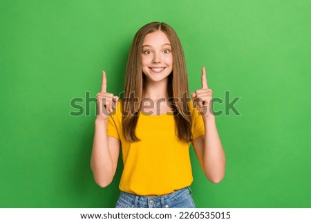 Portrait of positive nice girl indicate fingers up empty space proposition isolated on green color background