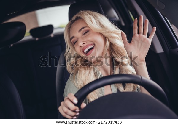 Portrait of positive nice girl sitting\
driver seat hold wheel have good mood listen\
music