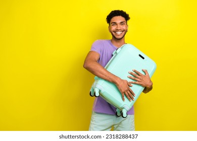 Portrait of positive nice person beaming smile hands hold hug suitcase empty space isolated on yellow color background - Shutterstock ID 2318288437