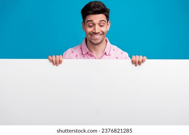 Portrait of positive person toothy smile look interested down empty space blank isolated on blue color background - Shutterstock ID 2376821285