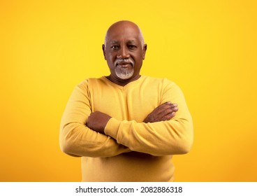Portrait Of Positive Senior African American Man Posing With Crossed Arms On Orange Studio Background. Happy Elderly Black Male In Casual Wear Smiling At Camera, Looking Confident