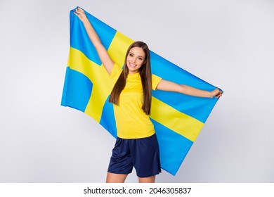 Portrait Of Positive Soccer Sport Fan Girl Hold Swedish Flag Celebrate Her National Team Win On World Championship Cup Match Wear Football Kit Isolated Over Grey Color Background