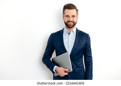 Portrait of a positive successful caucasian bearded business man in a suit, seo, consultant, broker, standing on isolated white background, holding laptop, looking at camera, smiling friendly - Shutterstock ID 2216641603