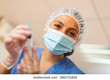 Portrait Of Positive Woman Healthcare Worker Holding Syringe For Injection Or Vaccination