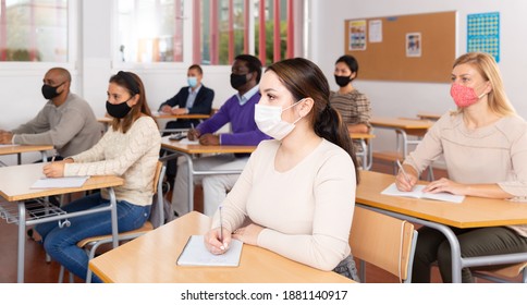 Portrait Of Positive Woman Sitting In Class Working During Group Business Training, All People Wearing Face Masks For Disease Protection