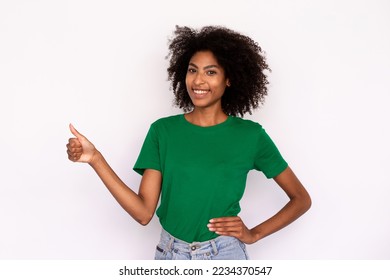 Portrait of positive young woman making thumb up gesture over white background. African American lady wearing green T-shirt and jeans showing like symbol. Success and approval concept - Powered by Shutterstock