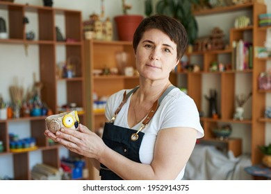 Portrait Of A Pottery Master Woman Showing The Finished Work