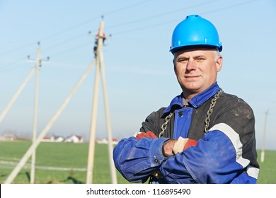 Portrait Of Power Line Repairman Electrician Worker On Electric Post Pole Work