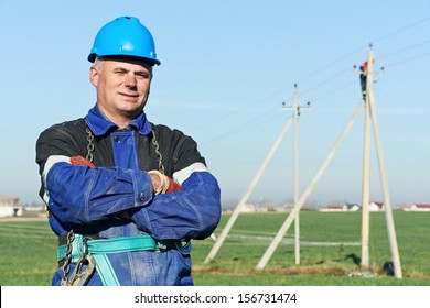 Portrait Of Power Line Repairman Electrician Worker On Electric Post Pole Work