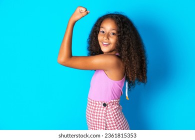 Portrait of powerful cheerful beautiful kid girl with afro curly hairstyle wearing pink T-shirt showing muscles. - Powered by Shutterstock