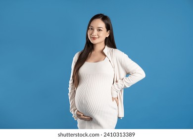 Portrait of pregnant asian woman, isolated on blue background - Powered by Shutterstock