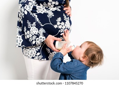 Portrait of a pregnant woman with baby child drink milk bottle